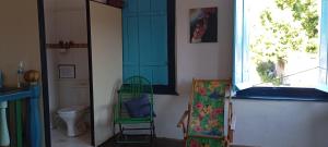 a room with a green chair and a window at Casarão D'Ávila aluguel por temporada in Goiás