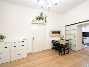 a kitchen with white cabinets and a table with chairs at City Center Apartment in Brno