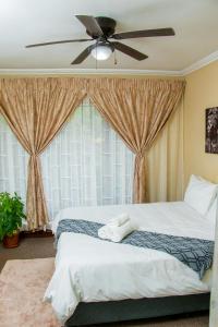 a bedroom with two beds and a ceiling fan at Noah Garden in Johannesburg +24 photos