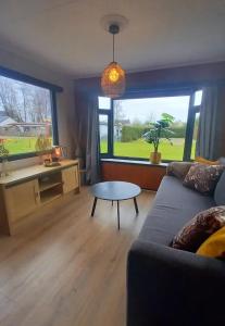 ein Wohnzimmer mit Sofa und Tisch in der Unterkunft De Hooglander in Westergeest