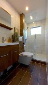 ein Badezimmer mit Badewanne, Toilette und Waschbecken in der Unterkunft De Hooglander in Westergeest