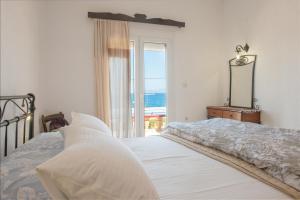 a bedroom with a bed with a view of the ocean at Poppy Villas in Agios Nikolaos +112 photos