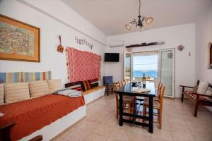 a living room with a couch and a dining room at Poppy Villas in Agios Nikolaos