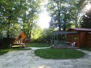 a cabin with a table and a bench in the yard at Chalet l'écureuil in Treigny