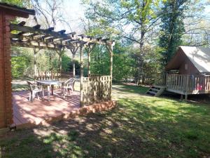 a patio with a table and chairs in a yard at Chalet l'écureuil in Treigny