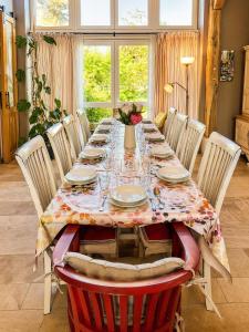a dining room table with chairs and a table cloth at Gîte LA MELINOTHE - 12 personnes - Grand gîte de charme indépendant 5 étoiles in Paisy-Cosdon