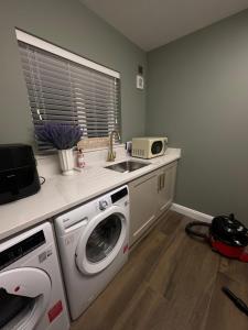 a kitchen with a washing machine and a sink at Anna and Jims Cottage in Claudy