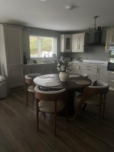 a kitchen with a table and some chairs and a kitchen with at Anna and Jims Cottage in Claudy