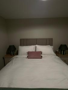 a large white bed with a brown pillow on it at Anna and Jims Cottage in Claudy +2 photos