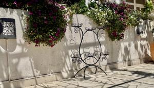 a bench sitting on the side of a wall with flowers at Villa Misita Elegant SeaView Rooms in Dubrovnik