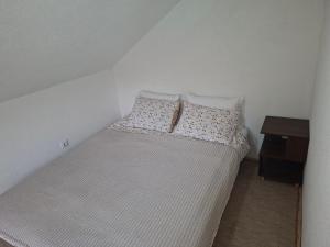 ein kleines Schlafzimmer mit einem Bett und einem Nachttisch in der Unterkunft Edison in Jablanica + 9 Fotos
