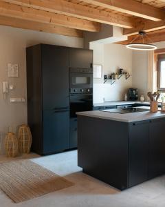 a kitchen with a black refrigerator and a stove at Sohana Chalet I Design I Apartment and Guest Rooms I Sauna I AC in Kappel-Grafenhausen