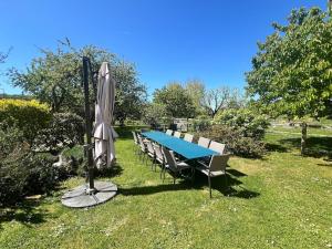 a blue table with chairs and an umbrella at Gîte LA MELINOTHE - 12 personnes - Grand gîte de charme indépendant 5 étoiles in Paisy-Cosdon