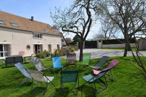 a group of chairs sitting in the grass in a yard at Gîte LA MELINOTHE - 12 personnes - Grand gîte de charme indépendant 5 étoiles in Paisy-Cosdon