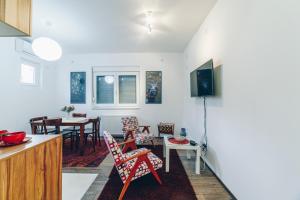 a kitchen and living room with a table and chairs at Sreckovic Apartmani 2 in Kragujevac