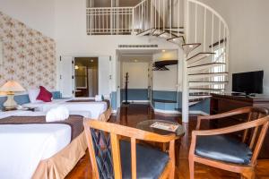a hotel room with two beds and a staircase at Brookside Valley Resort in Rayong