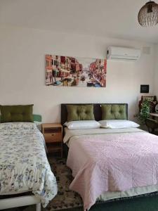 a bedroom with two beds and a painting on the wall at Ca Giulia in Chioggia