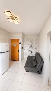 a living room with a couch and a refrigerator at Studio Moderno e Aconchegante , Centro Unai in Unaí