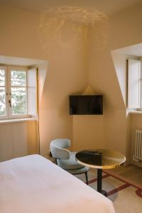 a room with a bed and a table and chairs at Villa Tri Men in Combrit