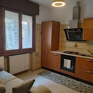 a kitchen with wooden cabinets and a stove top oven at Ca Giulia in Chioggia