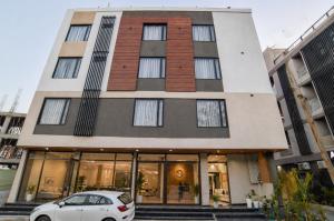 a white car parked in front of a building at Aceotel Select Virat, Vijay Nagar in Indore
