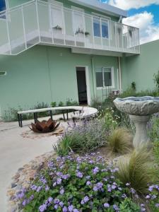 a house with a garden with flowers and a bird bath at Déjalo ser in Nueva Helvecia