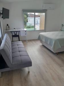 a bedroom with a bed and a chair and a desk at Déjalo ser in Nueva Helvecia