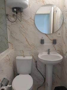 a bathroom with a toilet and a sink and a mirror at Déjalo ser in Nueva Helvecia