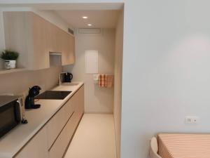 a small kitchen with white counters and a sink at Studio met zeezicht op Heldenplein in Knokke-Heist