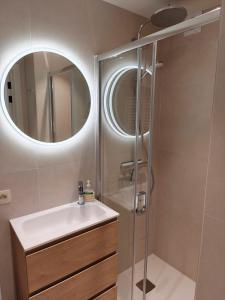 a bathroom with a sink and a shower with a mirror at Studio met zeezicht op Heldenplein in Knokke-Heist