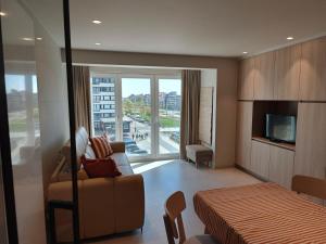 a hotel room with a bed and a couch and a television at Studio met zeezicht op Heldenplein in Knokke-Heist