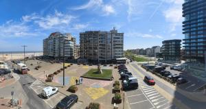 a city with cars parked in a parking lot at Studio met zeezicht op Heldenplein in Knokke-Heist