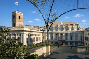 a large white building with a clock tower in a city at Le Erbe Apartment tra Locali e vita Universitaria in Genoa