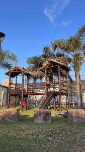 a playground with a slide in a park at Hotel El Cid in Villa Carlos Paz