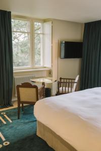 a hotel room with a large bed and a window at Villa Tri Men in Combrit