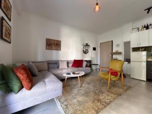 a living room with a couch and a table and a kitchen at Small Garden House in Draç