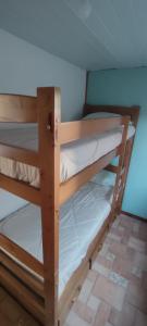 two bunk beds in a room with white sheets at Cabaña Dos Pinos in Durazno