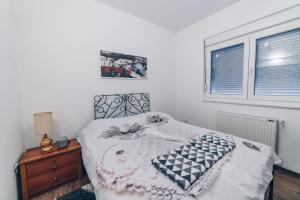 a bedroom with a bed and a window at Sreckovic Apartmani 2 in Kragujevac