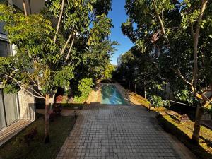 a swimming pool in the middle of a street with trees at Departamentos Nütuuk in Mérida
