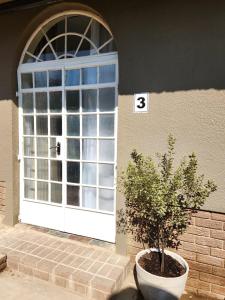 a white door with a tree in front of it at The Studios on Smuts in Ermelo