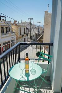 a table with two wine glasses on a balcony at K&M studio in Naxos Chora