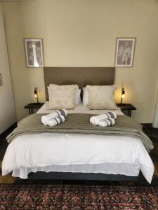 a bedroom with a large bed with pillows on it at The Studios on Smuts in Ermelo