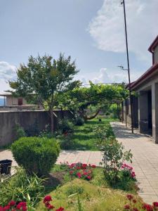 a garden with flowers and a sidewalk at Nia's Guesthouse in Zemo Alvani