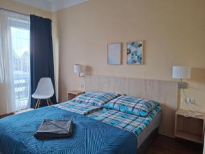 a bedroom with a bed with a blue blanket and a window at Omega Jantar in Jantar +49 photos