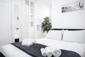 a bedroom with a white bed with towels on it at Le Erbe Apartment tra Locali e vita Universitaria in Genoa