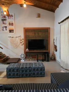 a living room with a couch and a large television at Cabana da Cris in Anchieta