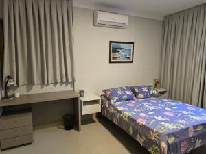 a small bedroom with a bed and a desk at Cabana da Cris in Anchieta +66 photos