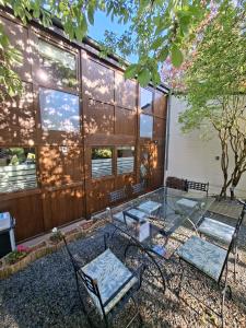 two chairs and a glass table in front of a house at Chalet tout confort in Virton