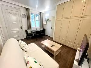 a living room with a white couch and a table at Maison cozy 2p- Jardin - Paris à 5 min - Métro in Maisons-Alfort