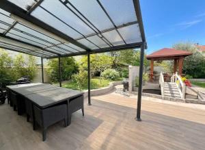 a pavilion with a table and chairs on a deck at Maison cozy 2p- Jardin - Paris à 5 min - Métro in Maisons-Alfort